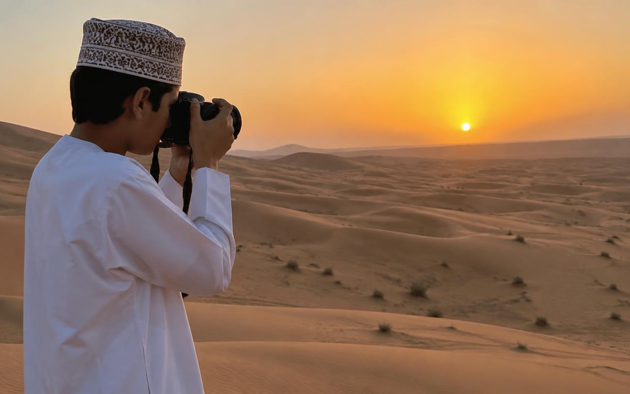 A young man taking photographs in the mountains
